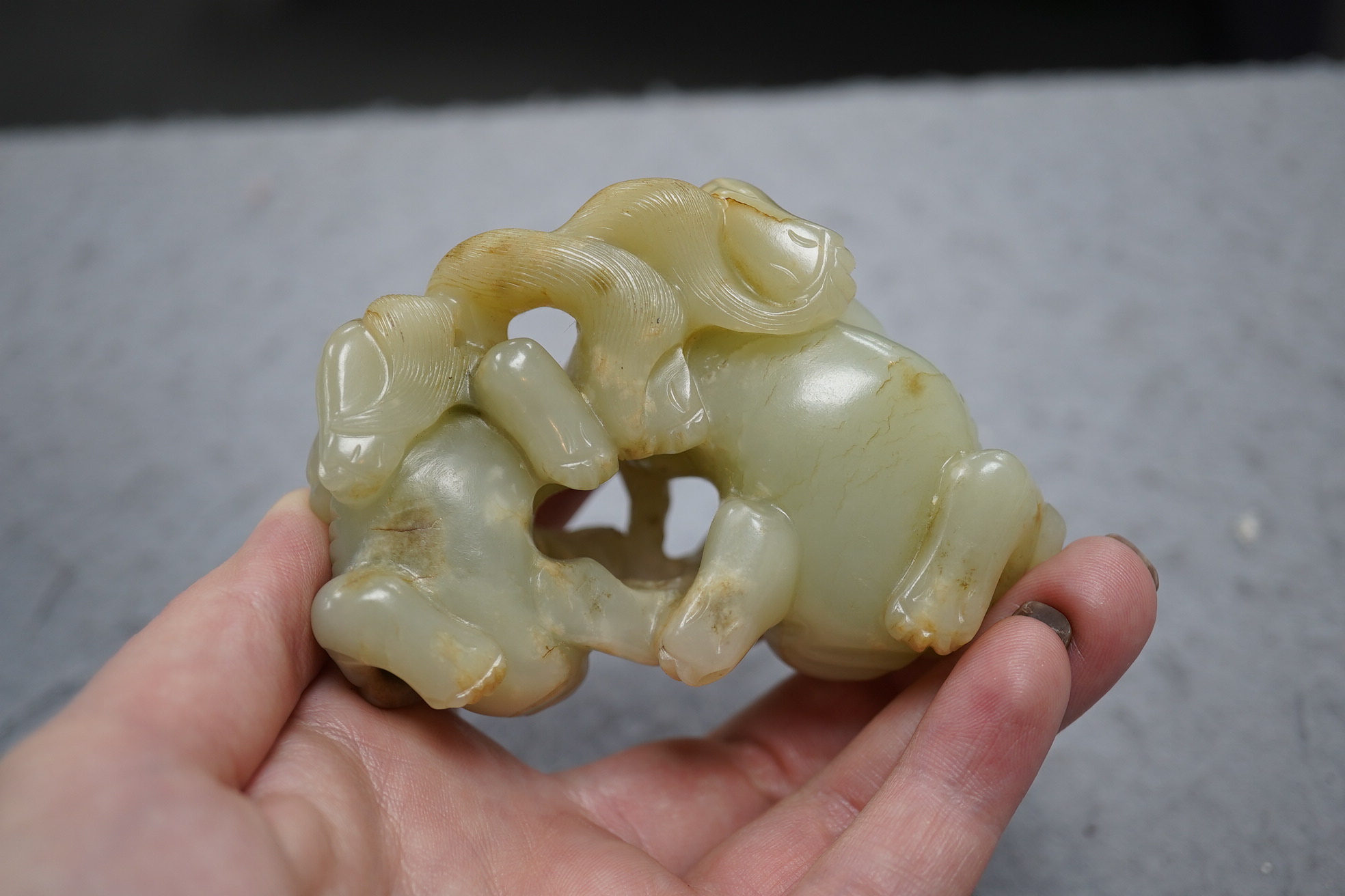 A Chinese celadon and russet jade group of two lion-dogs, 19th century